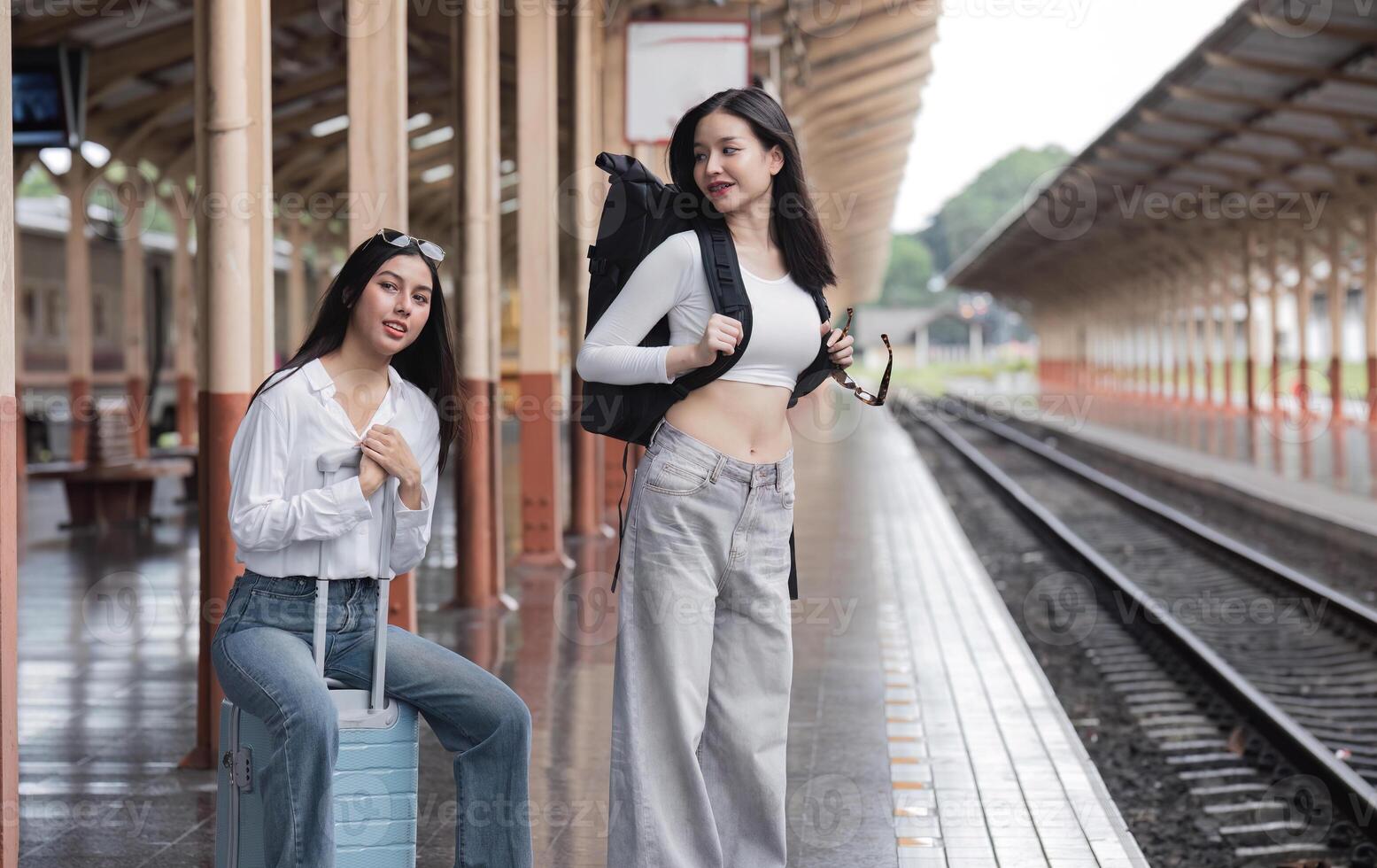 Young Lesbian Couple Waiting for Train at Train Station, Embracing Adventure and Travel Together photo