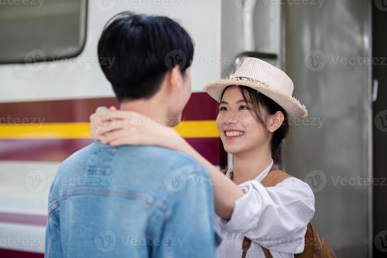 Young Couple Enjoying a Train Trip Together, Smiling and Embracing at the Station photo