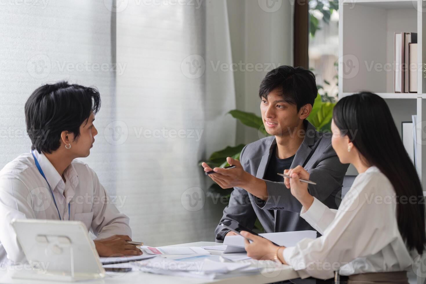 Diverse Team of Business Professionals Engaged in a Collaborative Meeting in a Modern Conference Room photo