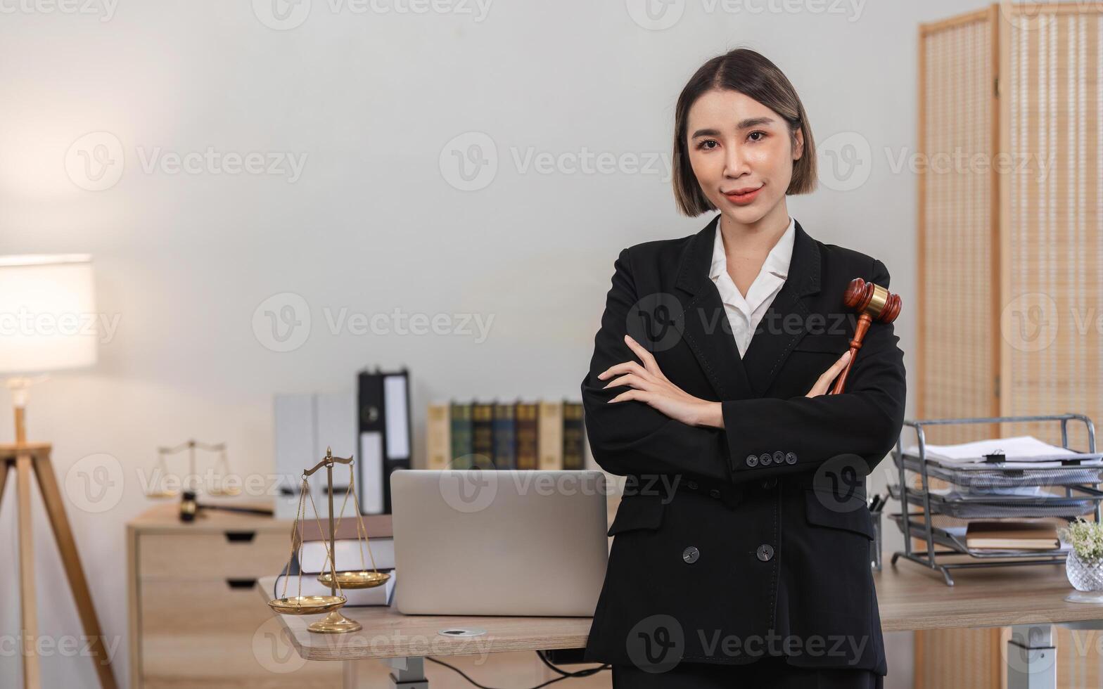 Confident Young Lawyer in Modern Office with Legal Books and Scales of Justice, Holding Gavel, Professional and Empowered photo