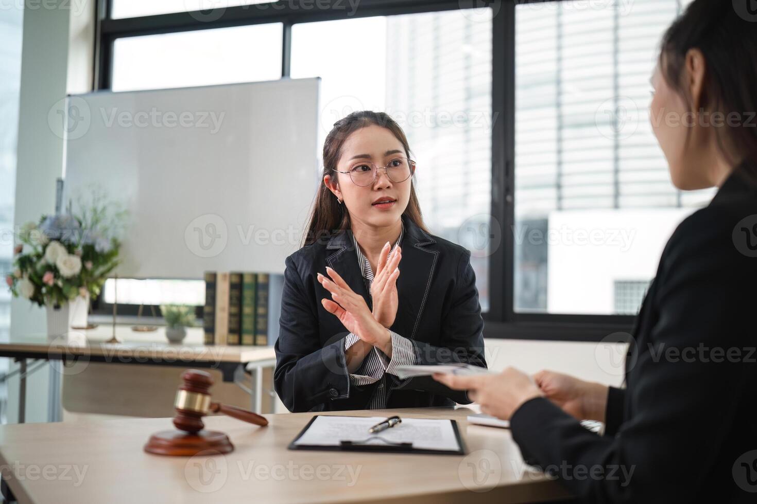 Confident Female Lawyer Denies Corruption Allegations in Modern Office Setting During Client Consultation photo