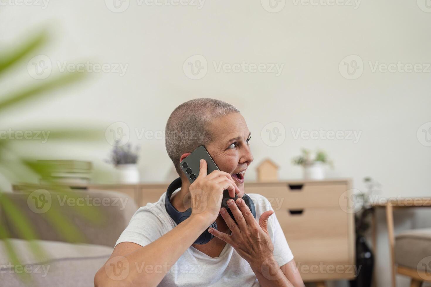 Elderly Woman Communicating via Telephone at Home, Engaging in a Conversation with Modern Technology photo
