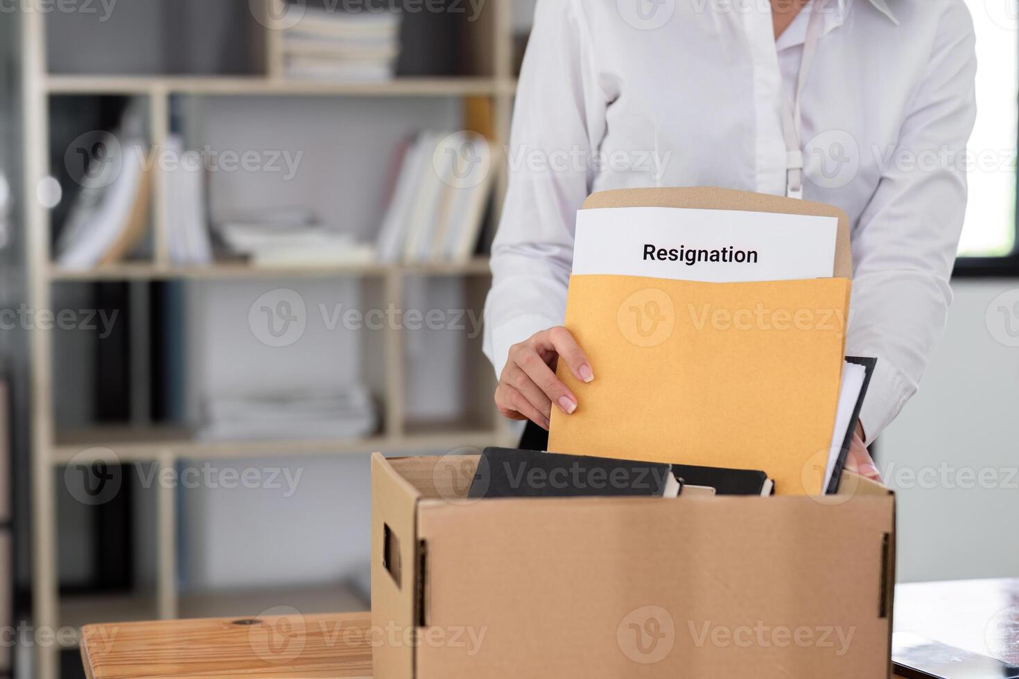 Young Female Office Worker Holding a Box with Resignation Document in Modern Office Setting photo