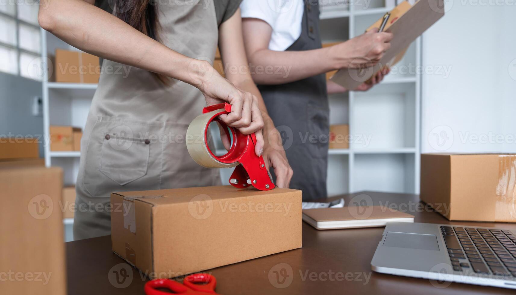 Couple Packing Boxes of Merchandise for Online Business in Modern Home Office Setting photo