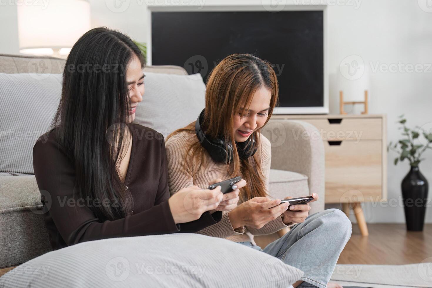Lesbian and LGBT Couple Enjoying Fun Time Playing Mobile Games Together at Home in a Cozy Modern Living Room photo