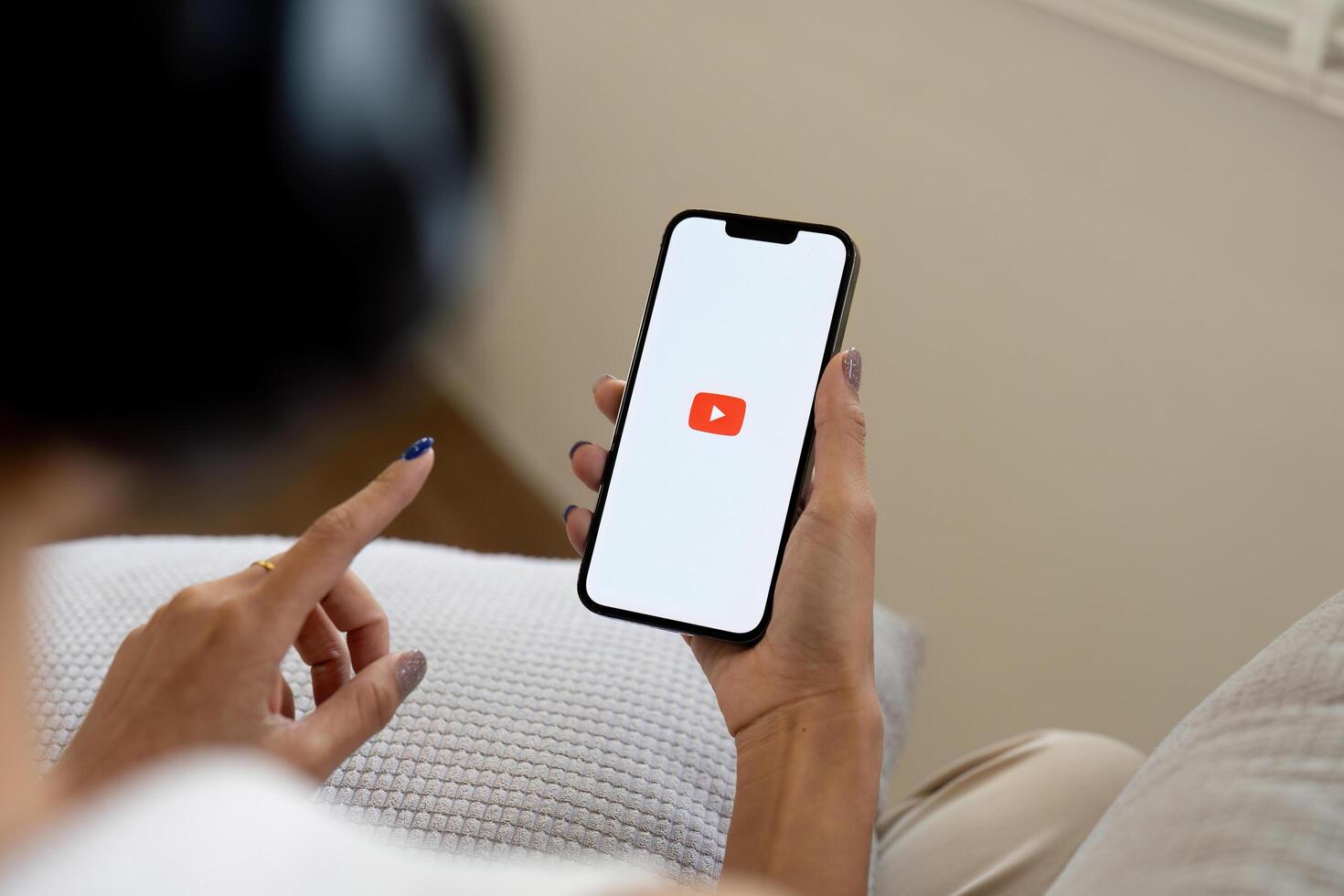 CHIANG MAI THAILAND JUN 25 2024 . Woman holding a iPhone 14 with social Internet service Youtube on the screen photo