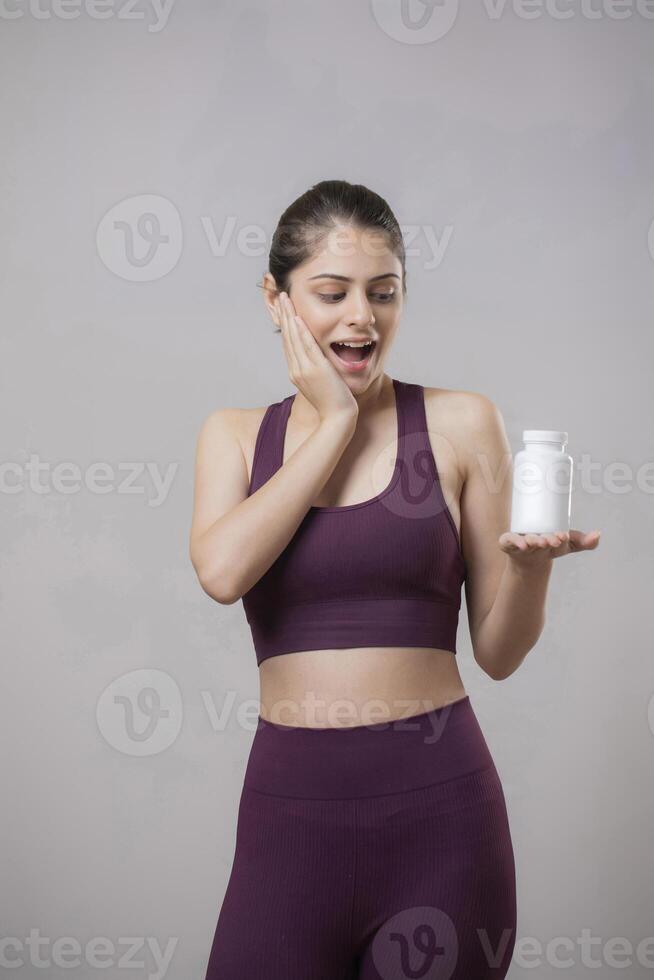 Beautiful Model Has A WOW Expression On Her Face While Holding A Pill Bottle In Her Hand photo