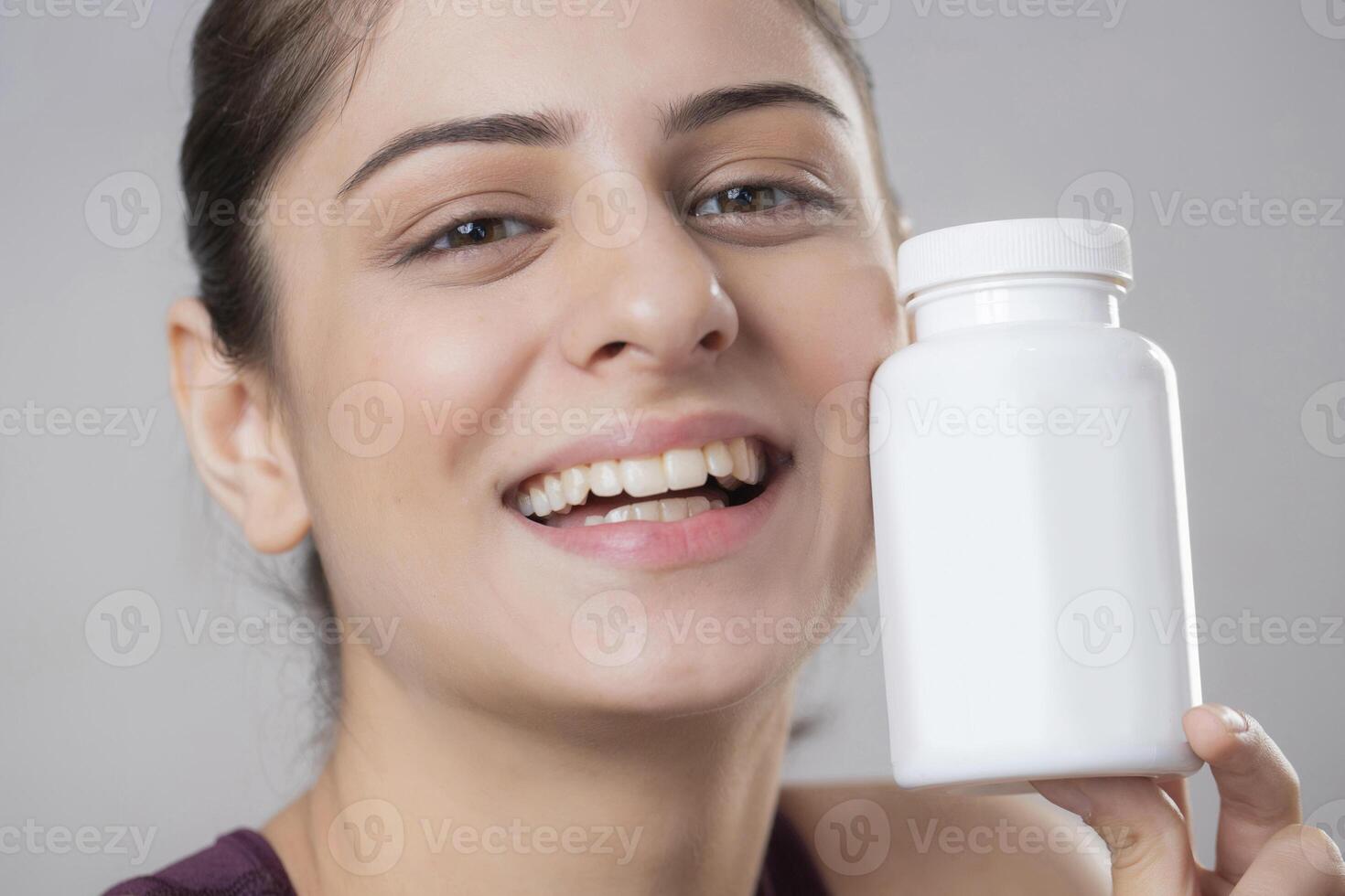 A Close-up Image Of A Gorgeous Woman Flaunting A Vitamin Bottle In Front Of The Camera photo