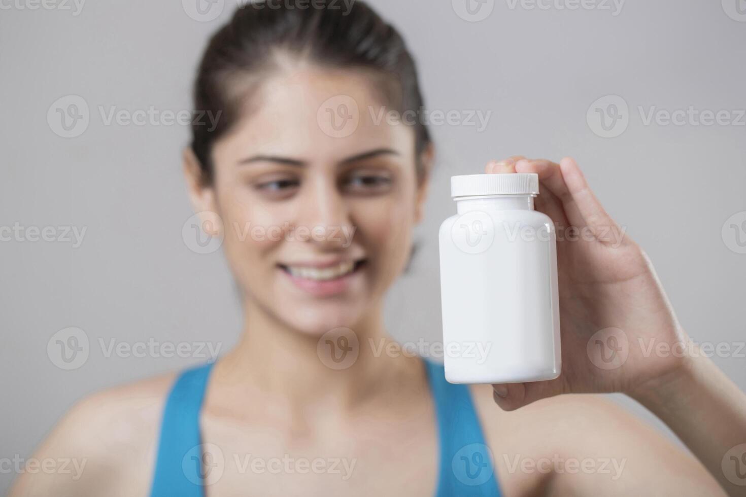 Beautiful Gorgeous Woman Showing Bottle Of Tablet photo