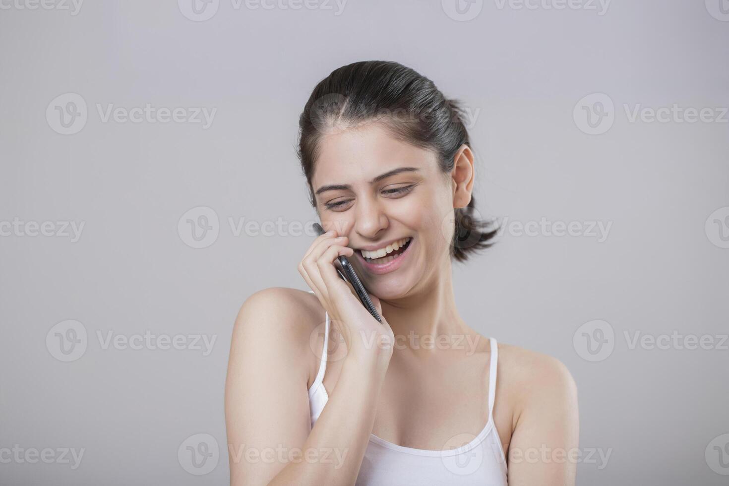A Glamorous Woman Smiling While Talking On The Phone photo