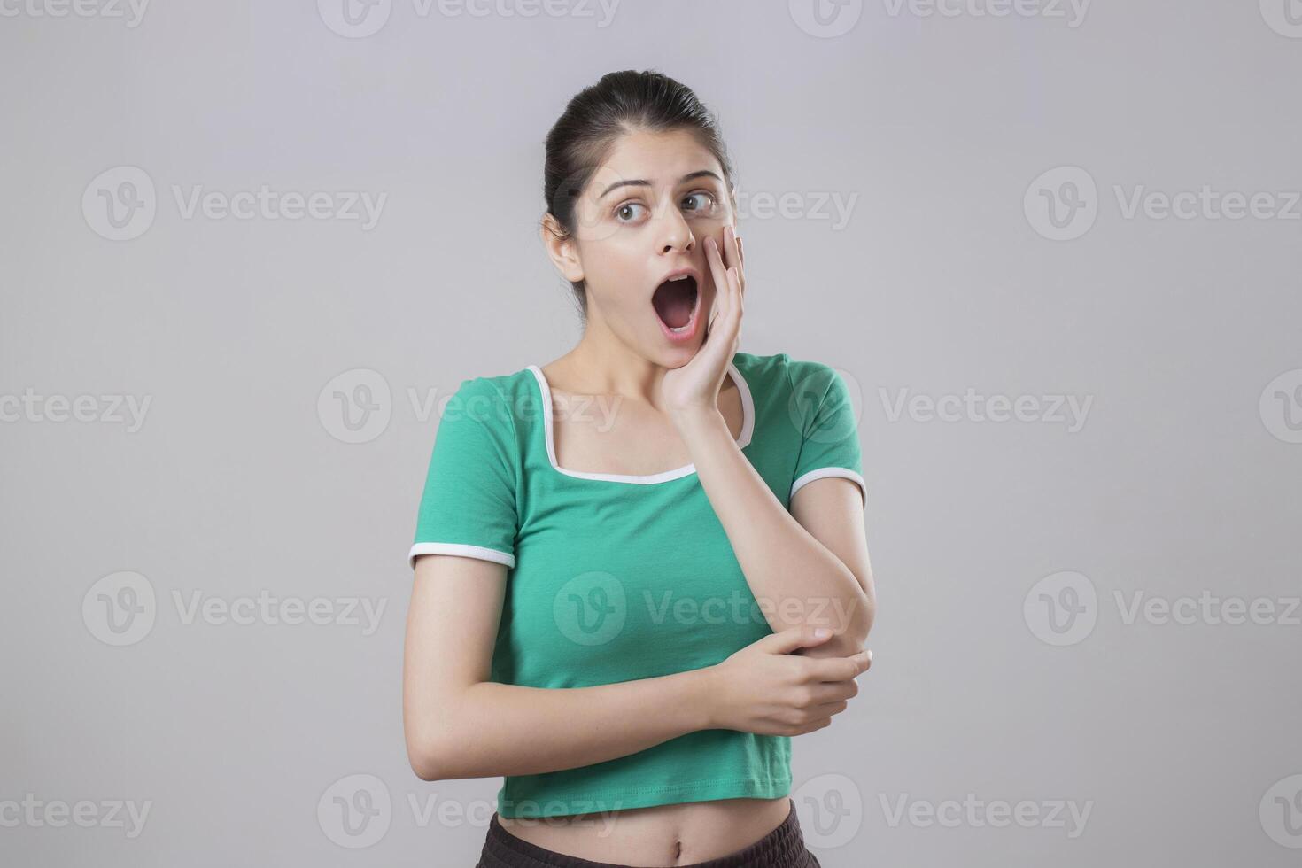 Shocked Woman Standing On A Grey Background photo