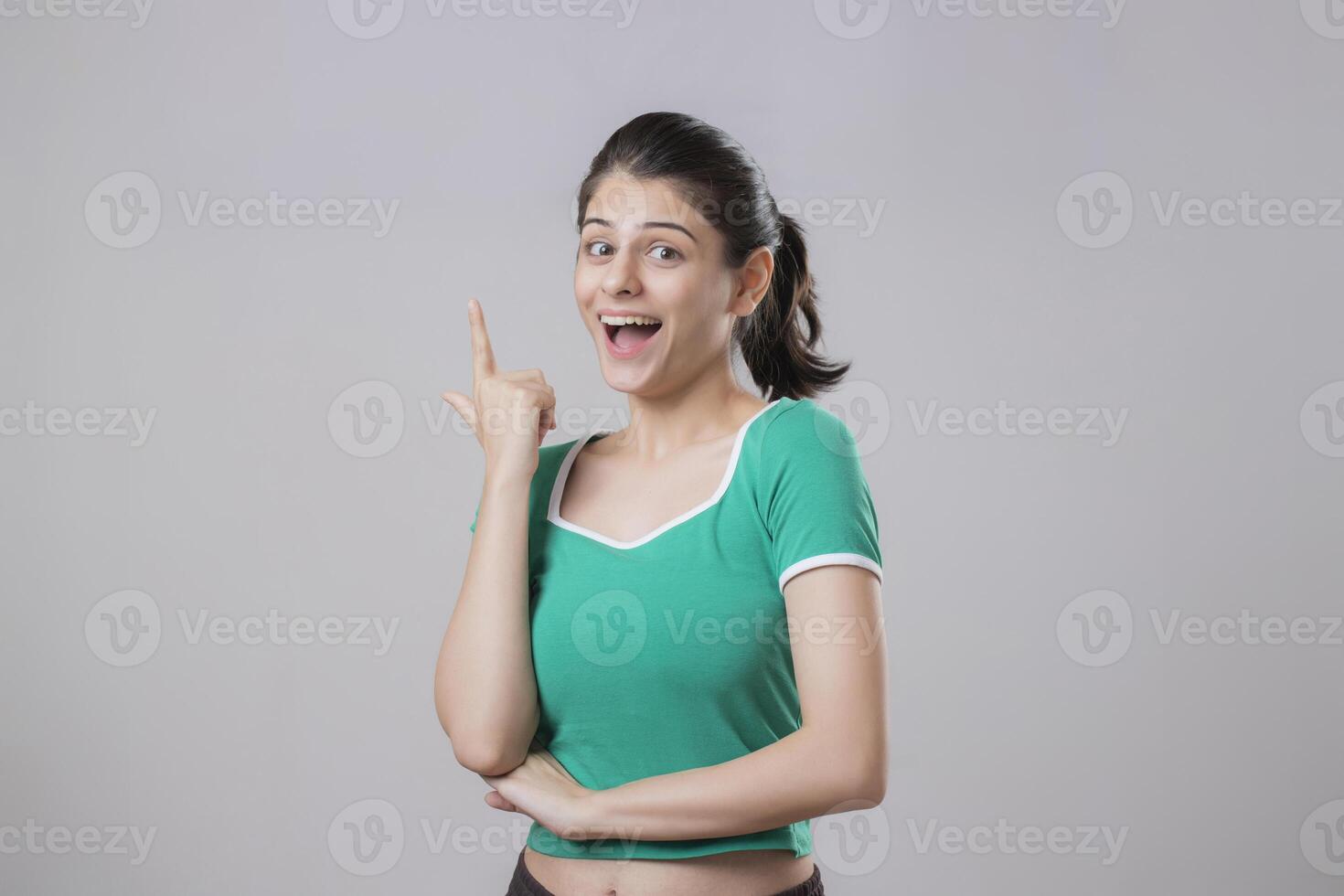 Charming Model Raises Her Fore Finger Up In Surprise Of Getting A New Idea photo