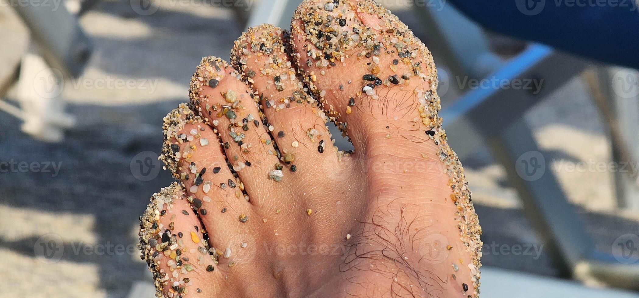 man's foot dirty with sand on the beach on the Ligurian coast on a hot summer day in 2024 in Spotorno photo