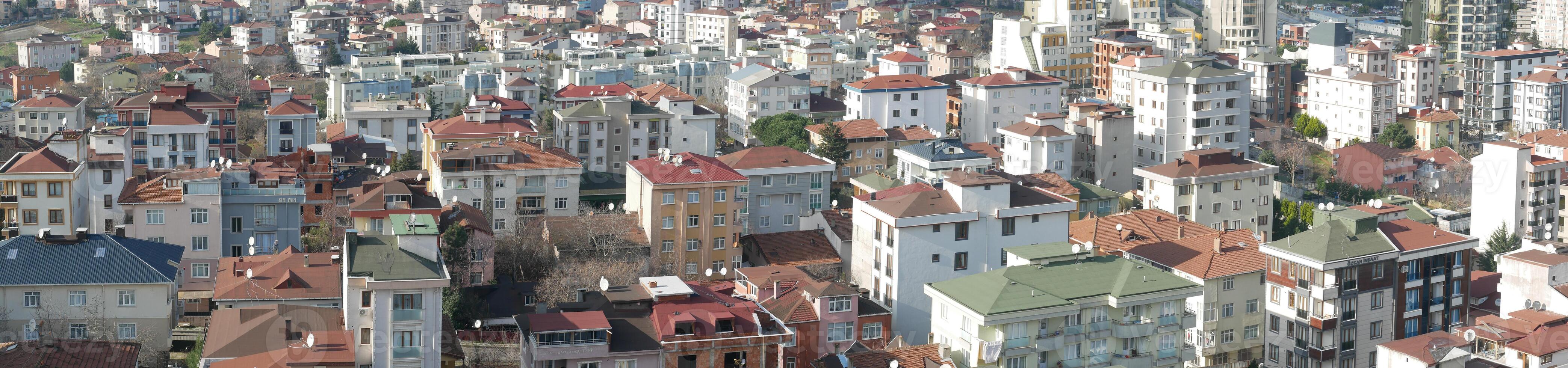 Aerial View of a Diverse Urban Landscape Featuring RedTiled Roofs and Tall HighRise Buildings photo