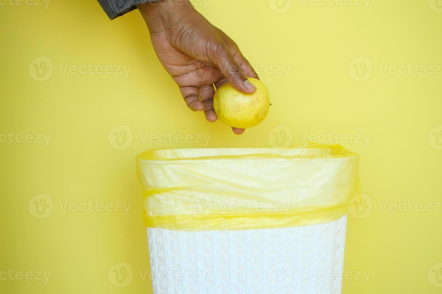 throwing lemon in a garbage bin photo