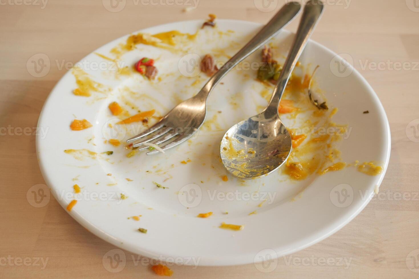 An empty dirty plate with a fork. photo