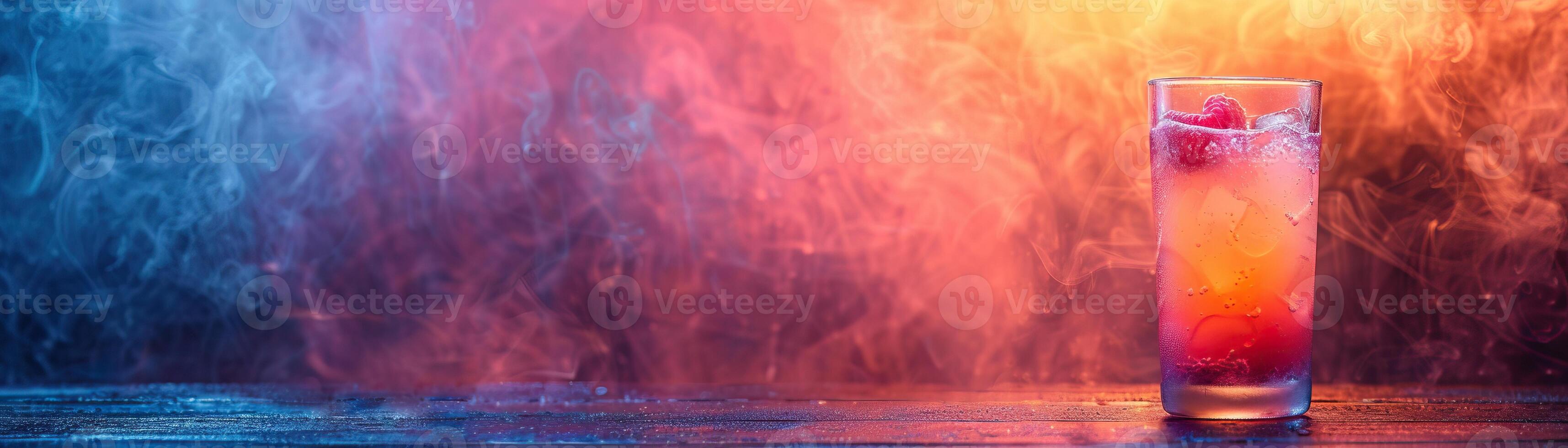 A glass of cocktail with raspberries on a wooden table against a background of red and blue smoke photo