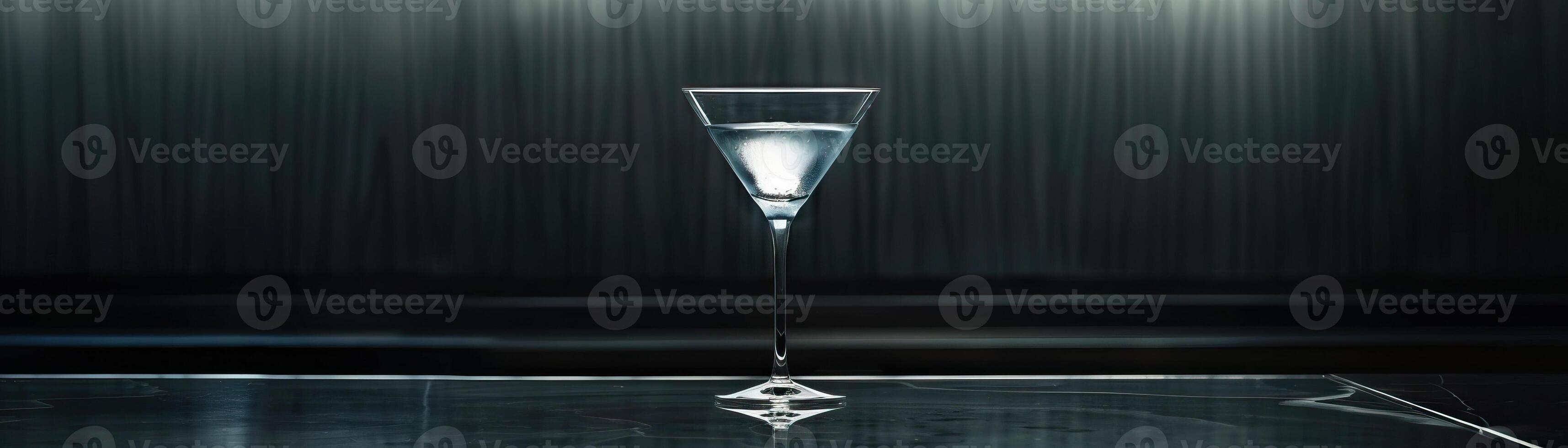 Martini glass on a bar counter with a dark background photo