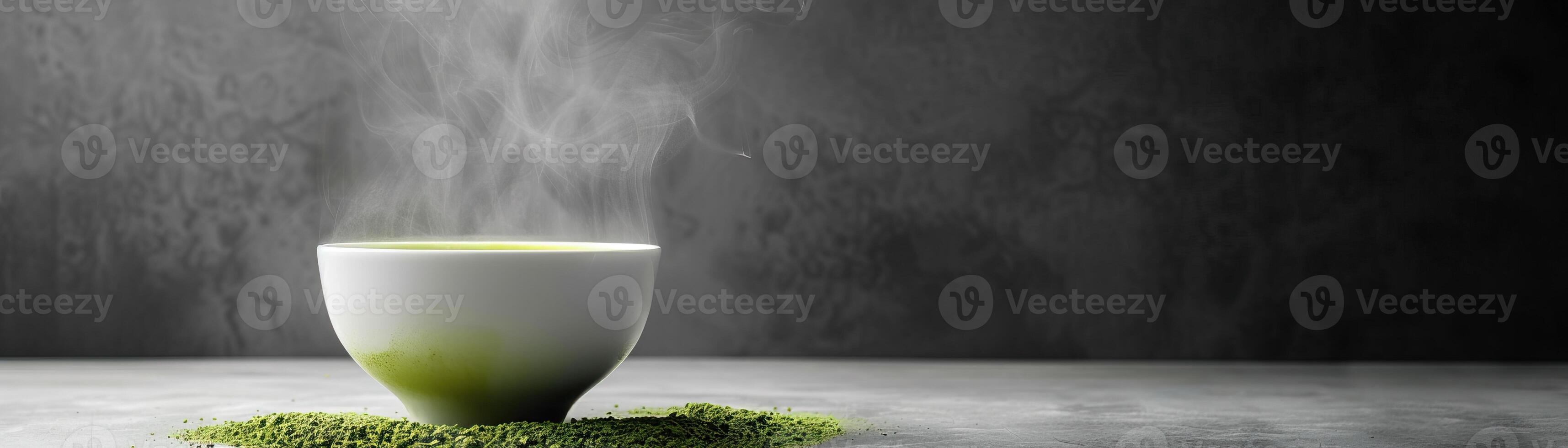 A bowl of hot matcha green tea with steam rising from it. The bowl is sitting on a bed of matcha powder. photo