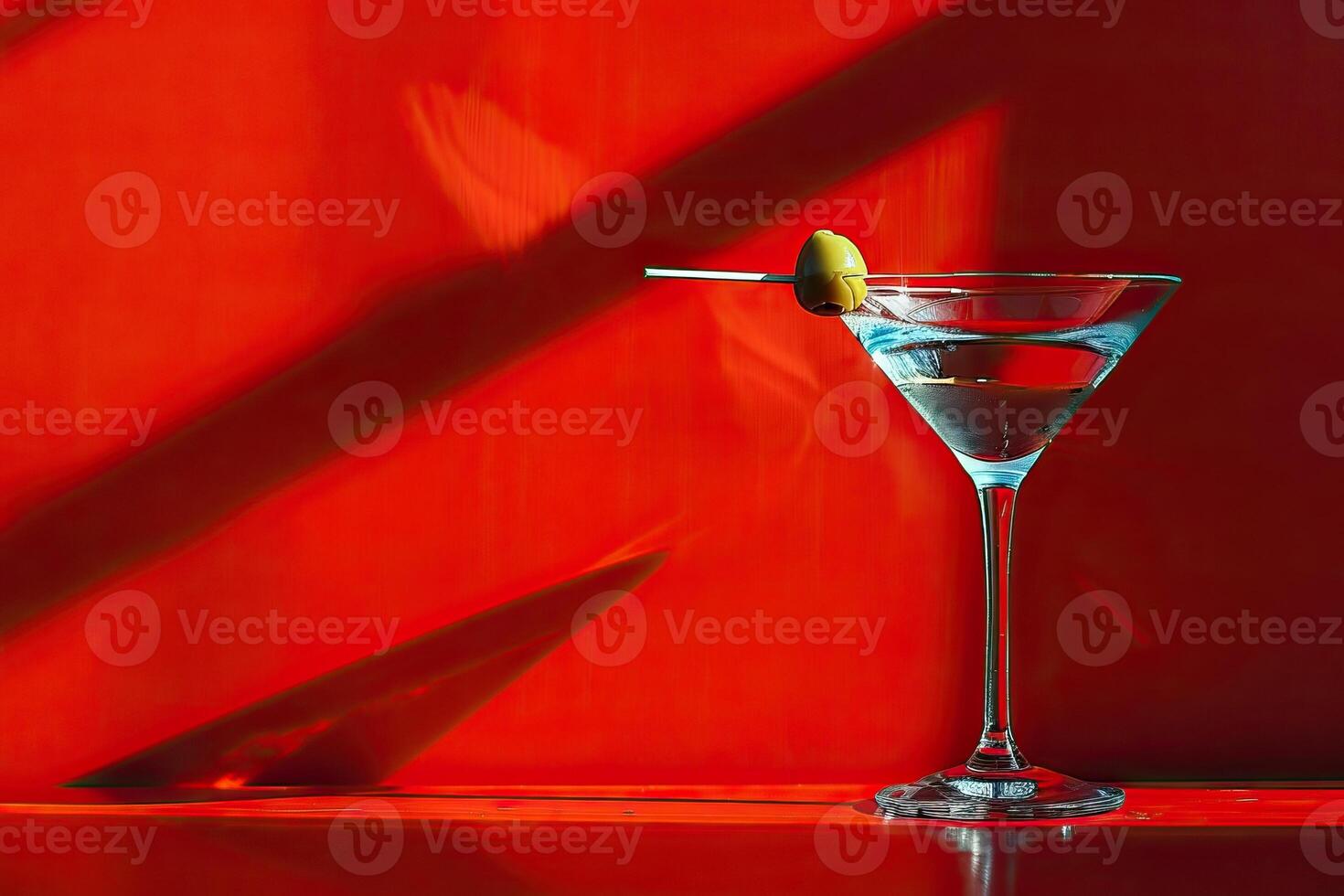 Martini glass with olive on red background. photo