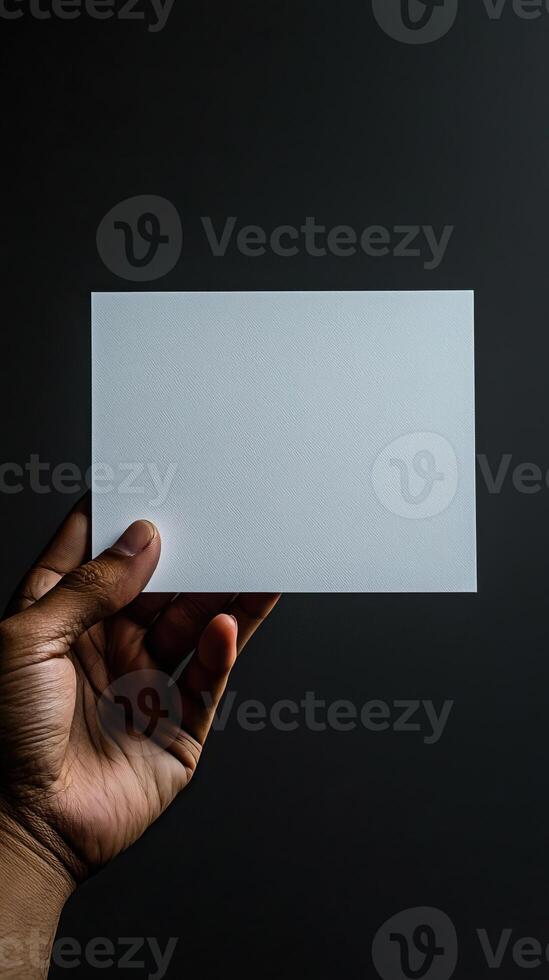 a hand holding a white blank rectangle paper, paper position horizontally, realistic photo