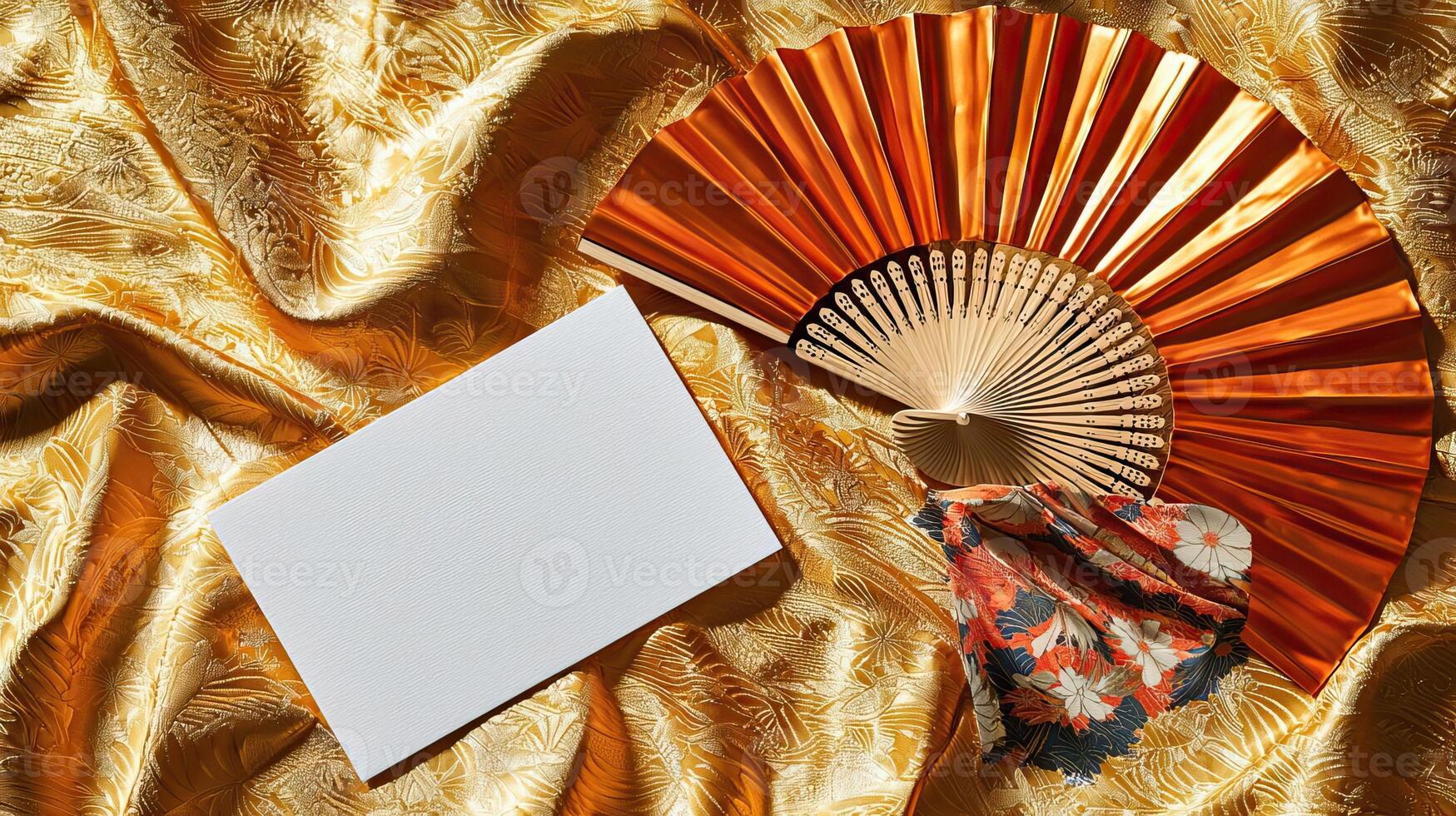 A mockup of a blank business card lying on golden Japanese silk, next to it lies a dancing Japanese fan photo