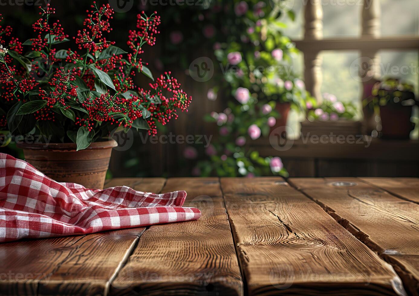 Rustic wooden table with a red checkered tablecloth and a potted plant in the background photo