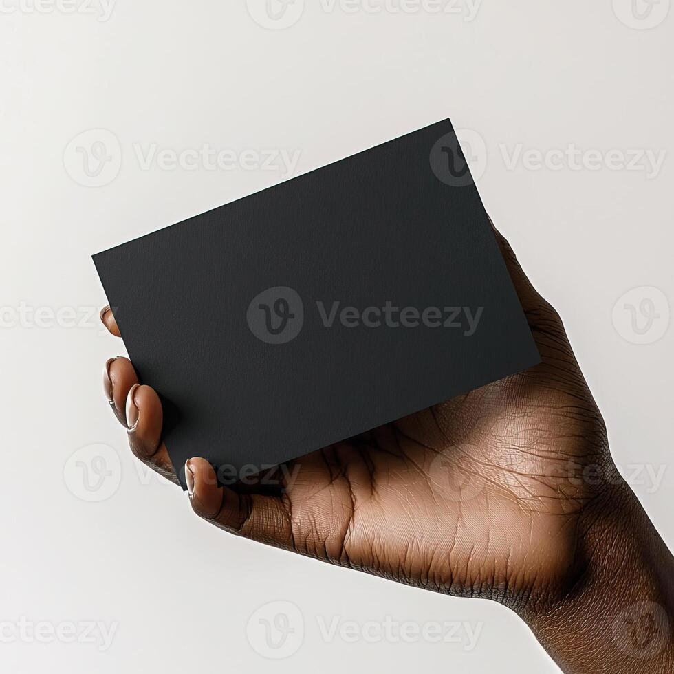 a dark skin hand holding a black blank business card The shot should be taken from a side perspective with the business card facing the camera photo