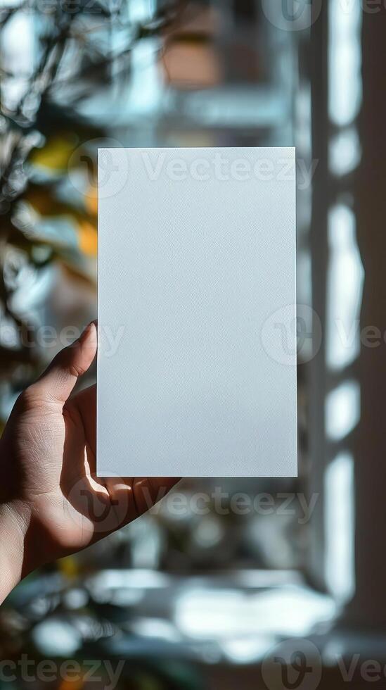 a hand holding a white blank rectangle paper, paper position horizontally, realistic photo