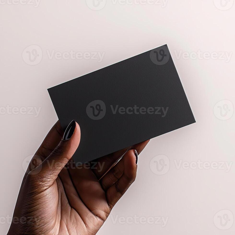 a dark skin hand holding a black blank business card The shot should be taken from a side perspective with the business card facing the camera photo