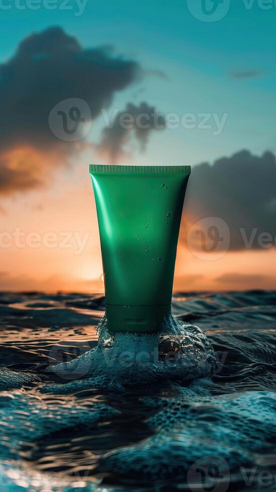 A green tube of sunscreen sits on the surface of the ocean at sunset. photo
