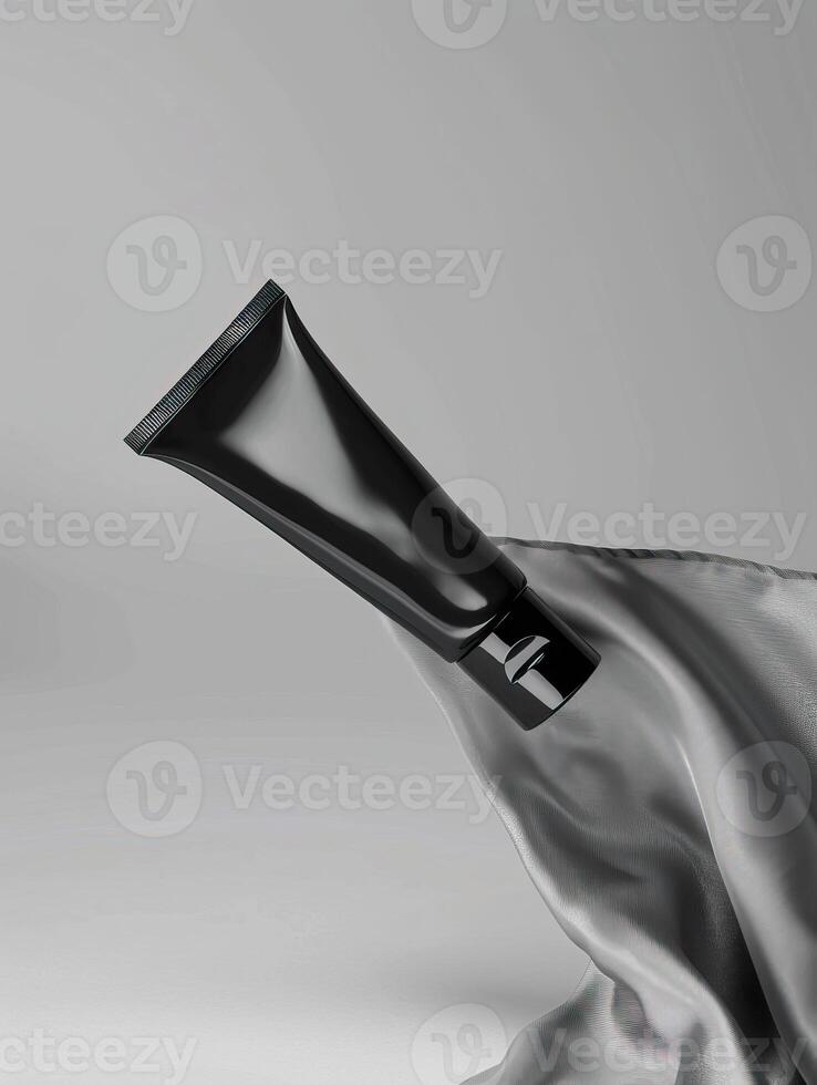 A black tube of face cream on a gray background. photo