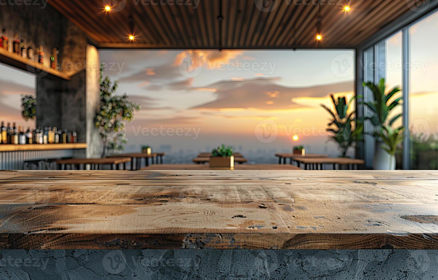 Modern rooftop bar with sunset view, wooden table in foreground, indoor plants, and panoramic windows creating cozy atmosphere. photo