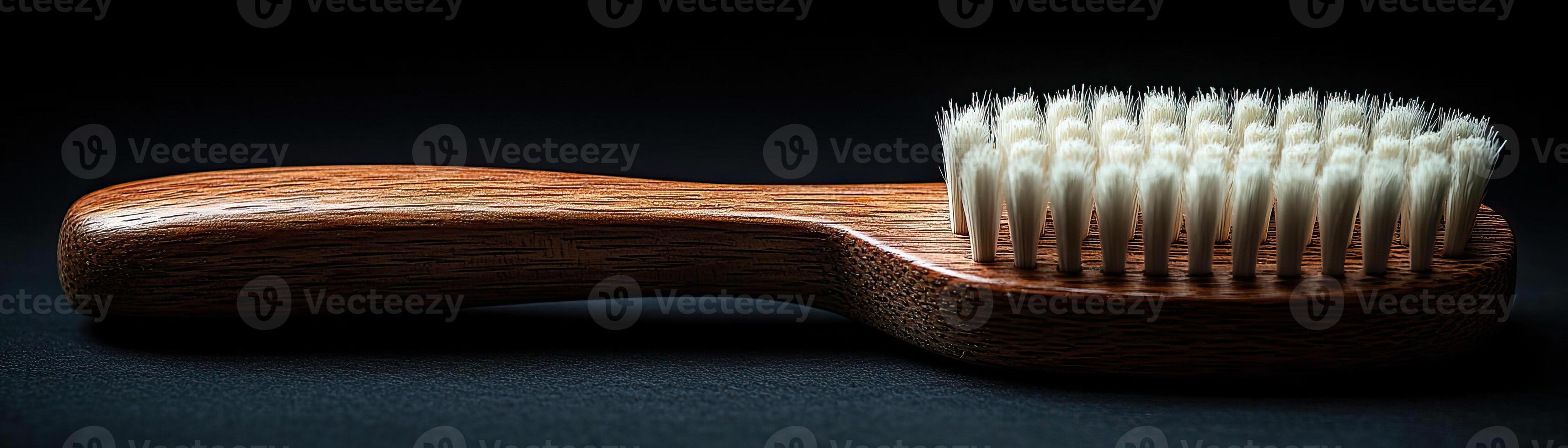 A handcrafted wooden brush with white bristles, contrasted against a dark, moody background, capturing a sense of timeless utility and elegance photo
