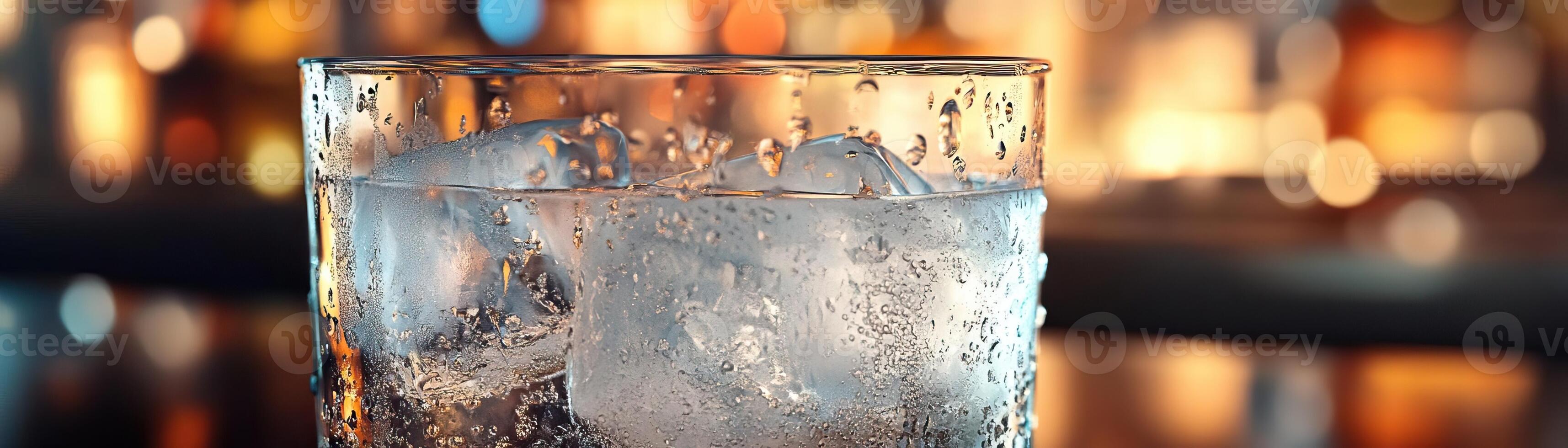 A closeup of a sparkling gin tonic, condensation on the glass, against a softfocus, modern bar background, wide negative space for editorial content photo