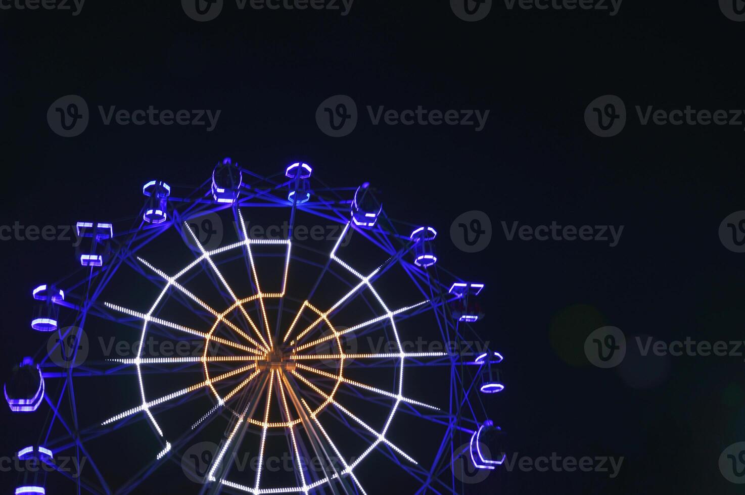 Ferris wheel with blue lights against the night sky. Attractions in the park. photo
