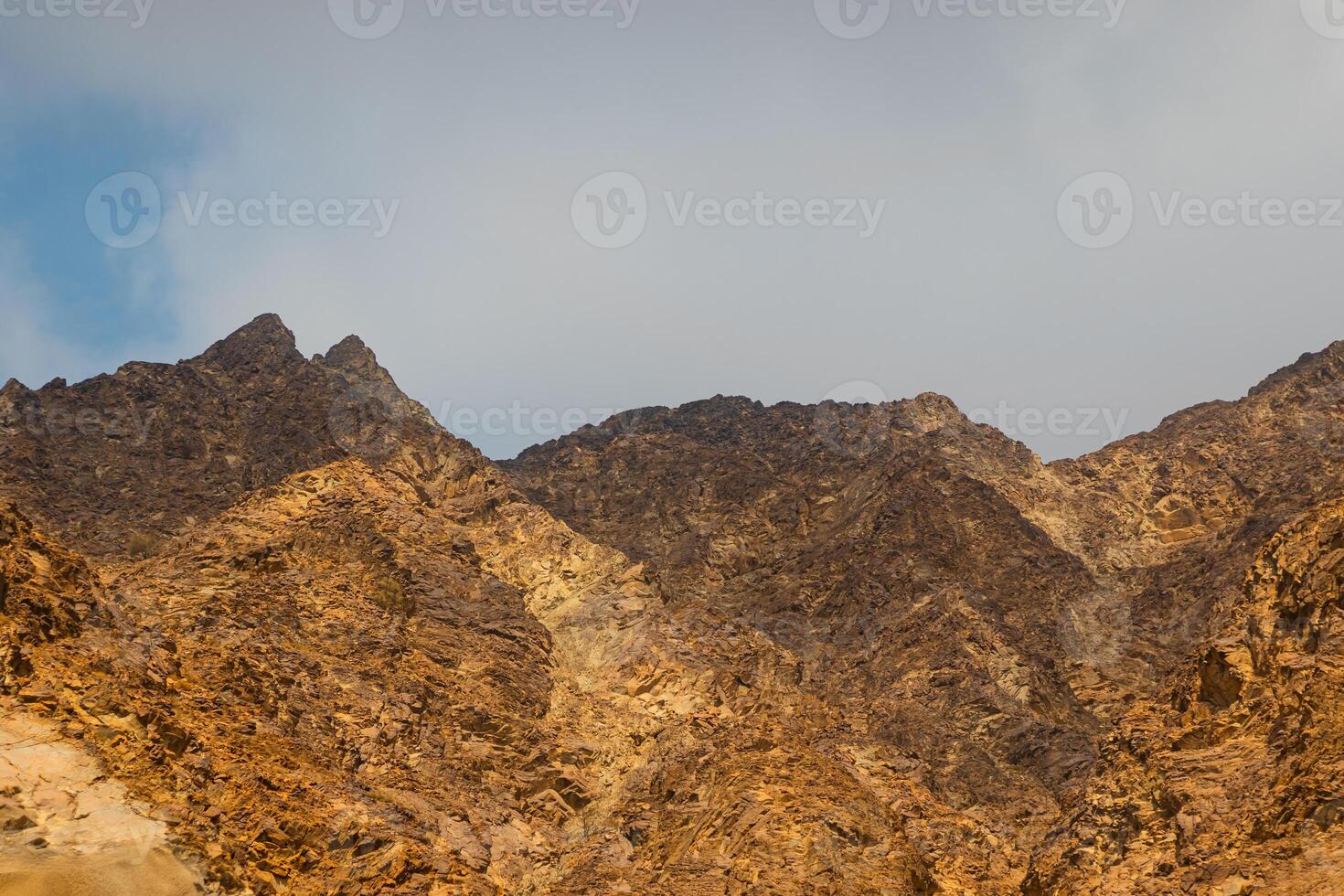 Fujairah mountains, extension of Omani Al Hajar mountain range. Cloudy winter day on empty street. High quality photo