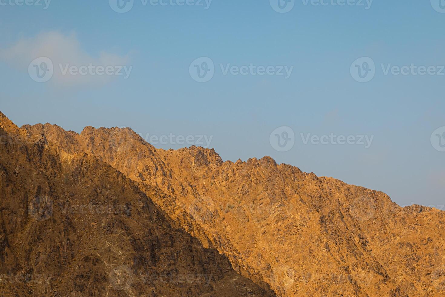 Fujairah mountains, extension of Omani Al Hajar mountain range. Cloudy winter day on empty street. High quality photo