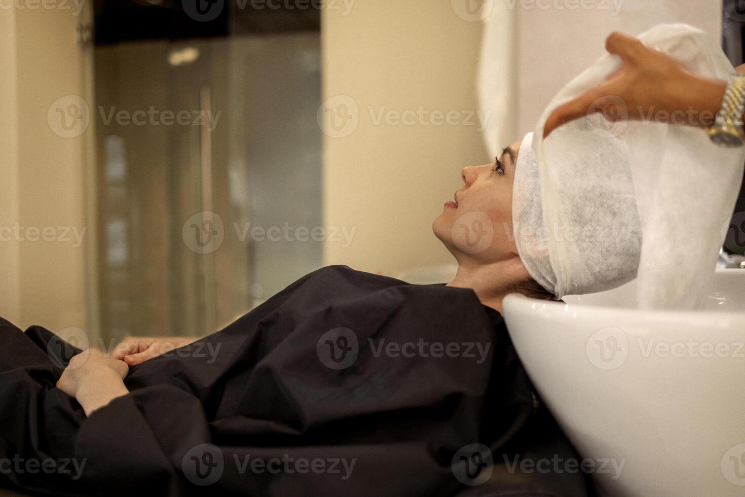 Cheerful young brunette womn enjoying head massage and washing hair photo