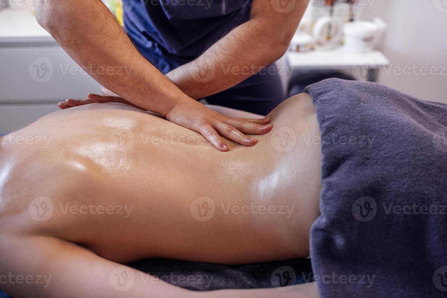 Young caucasian woman getting back massage in spa salon. photo
