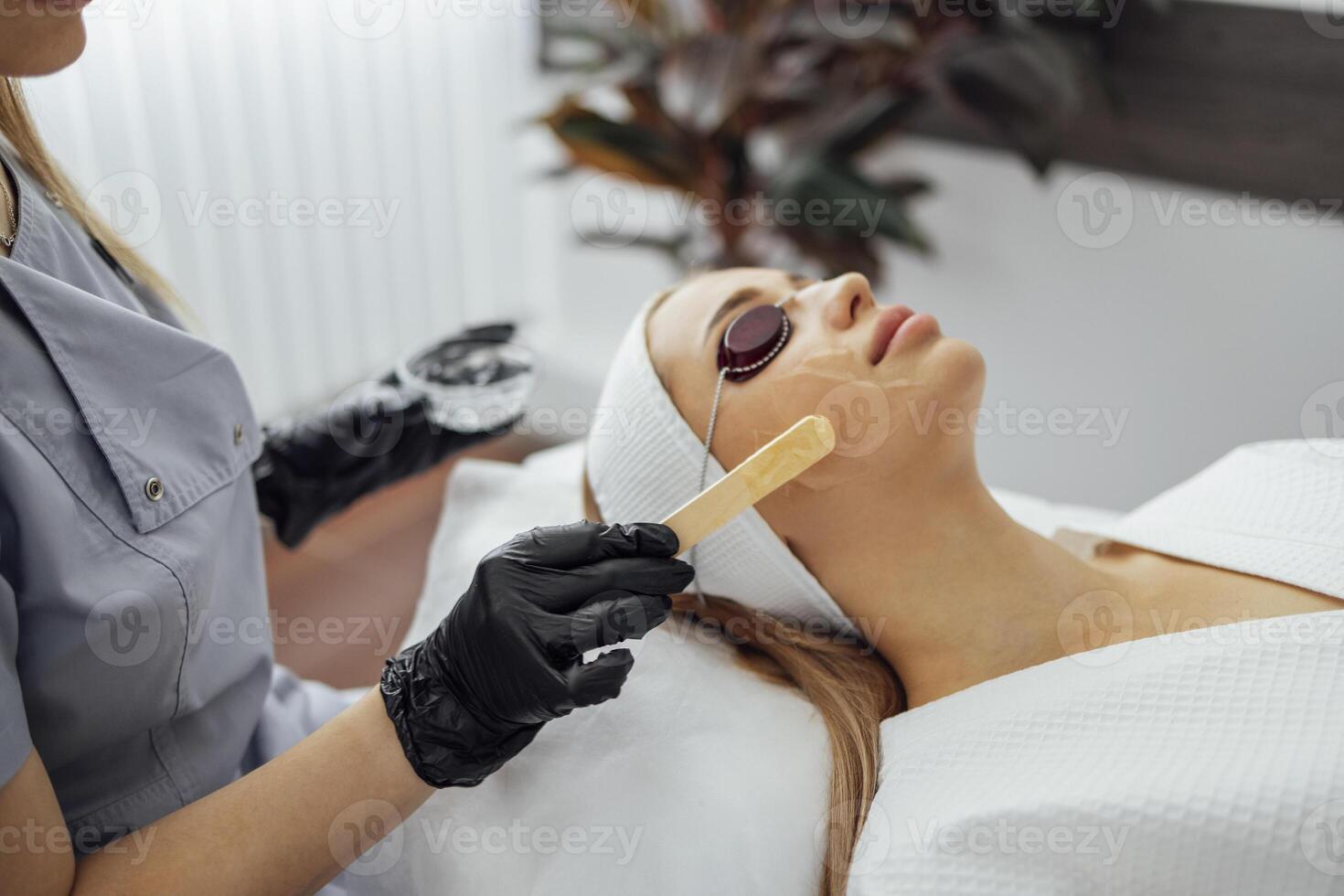 Beauty salon beautician applies cooling gel to clients skin. photo