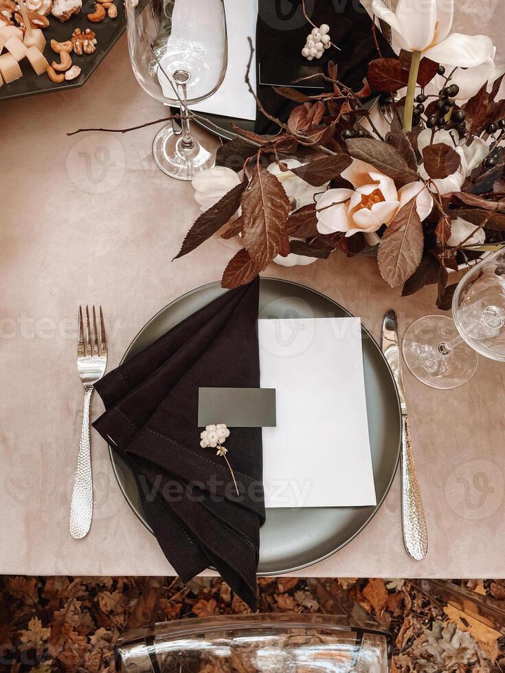 Table serving outdoors in the autumn forest. Black plate and napkin photo