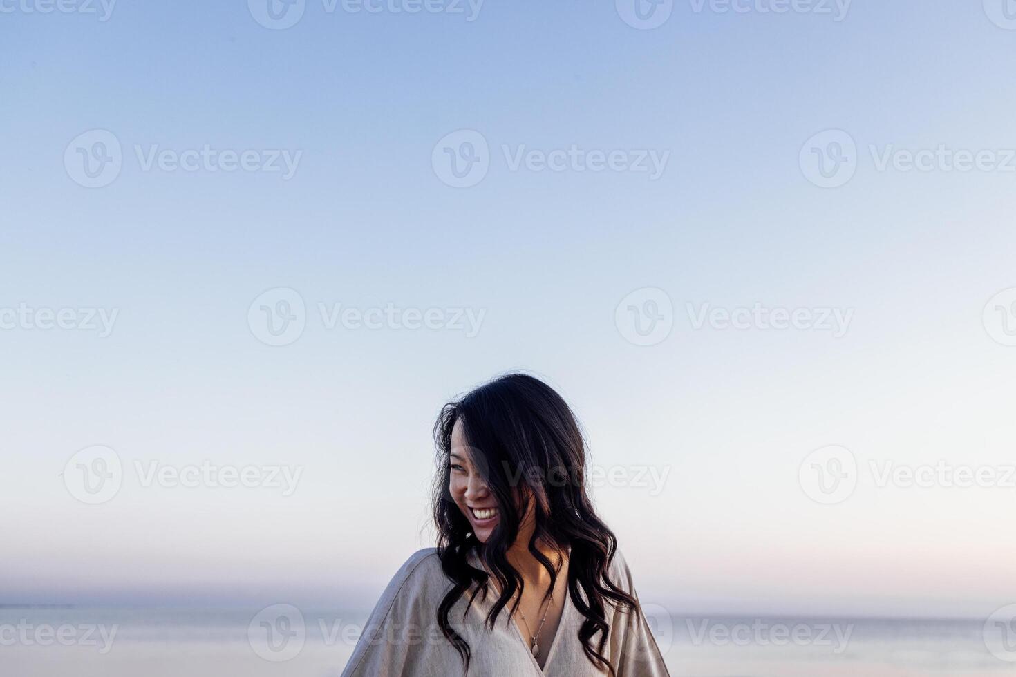Young attractive Asian with long wavy hair outdoors. A charming Korean woman photo