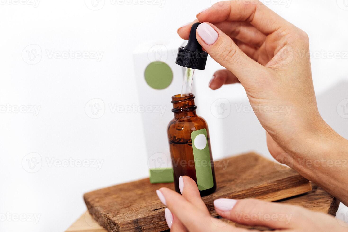 a woman is holding a bottle of essential oil photo