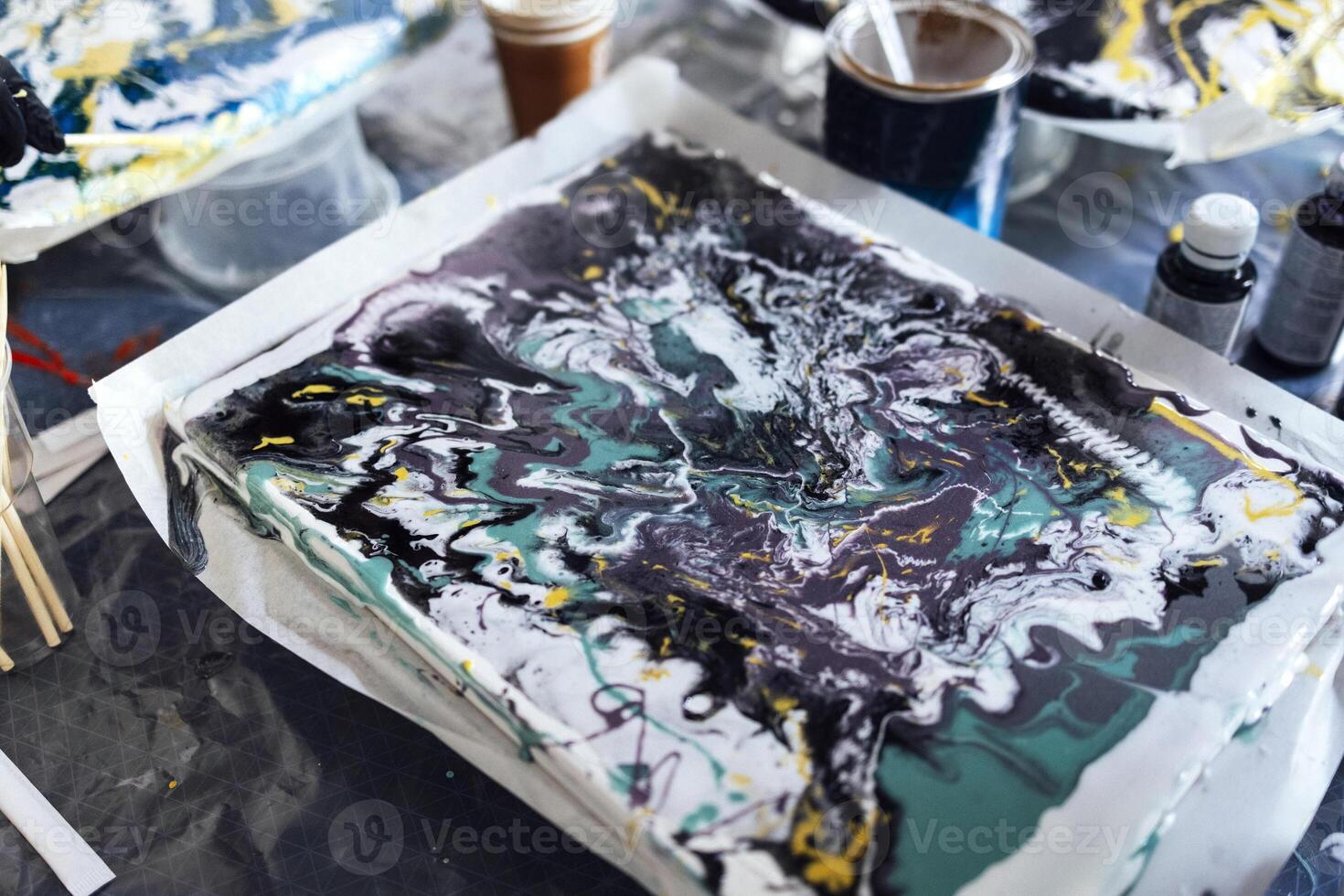 The process of creating a painting with acrylic paints. Abstract background. Acrylic Fluid Pouring. Painting tutorial or master class. photo