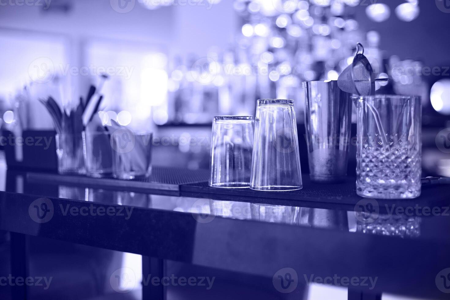 Bar counter with bottles in blurred violet background photo
