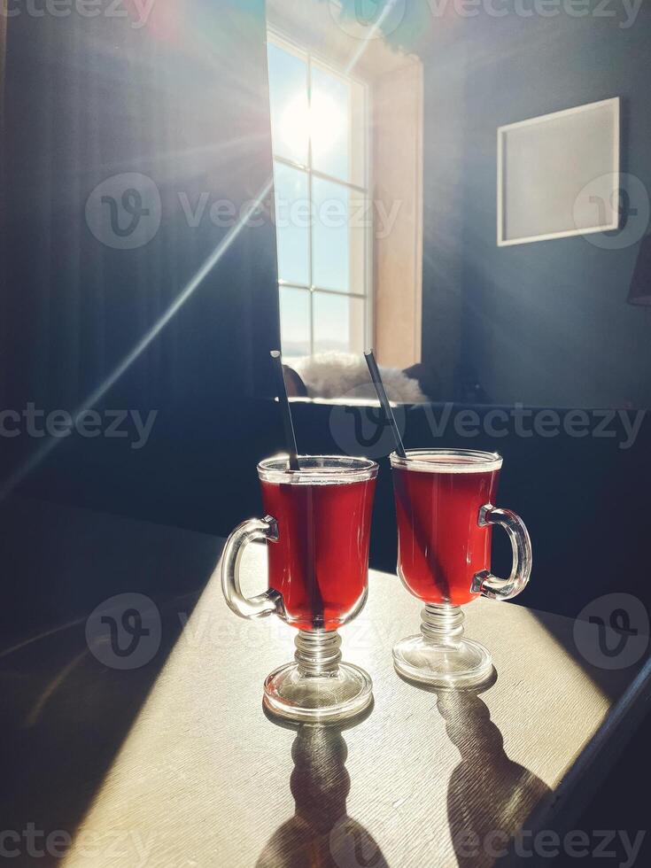 Two glasses of mulled wine on the windowsill overlooking the winter mountains photo