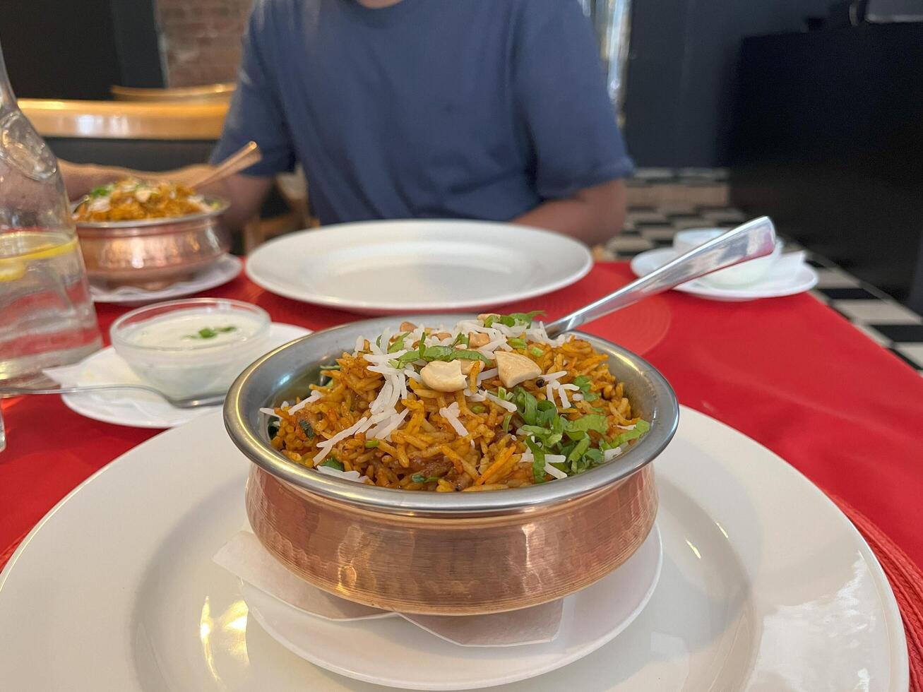 Rice biryani in a copper bowl on a restaurant table. Chicken biryani. Lamb biryani photo
