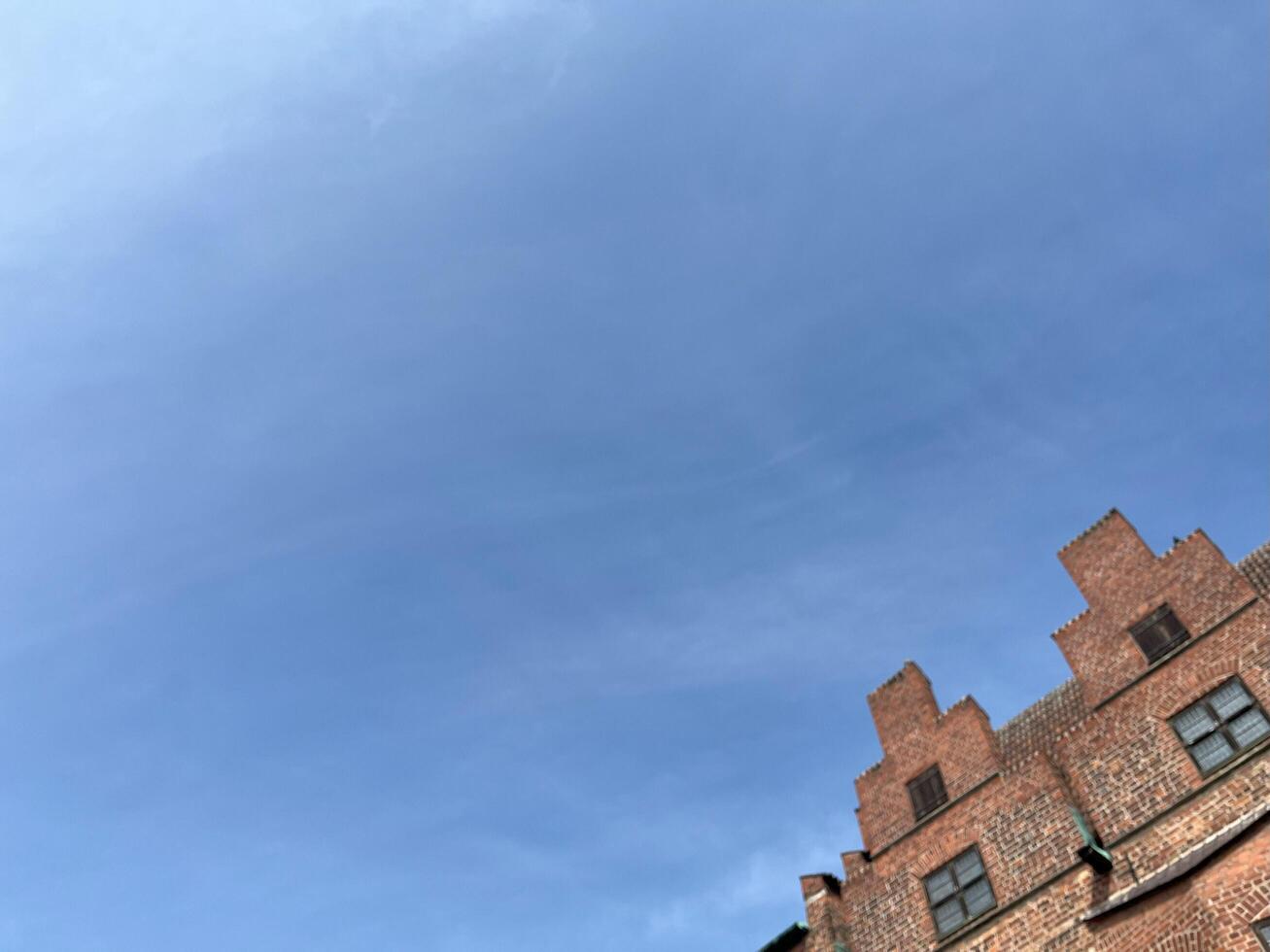 Clear blue sky with blurred old brick wall building. Red brick wall texture background. Brick wall background photo