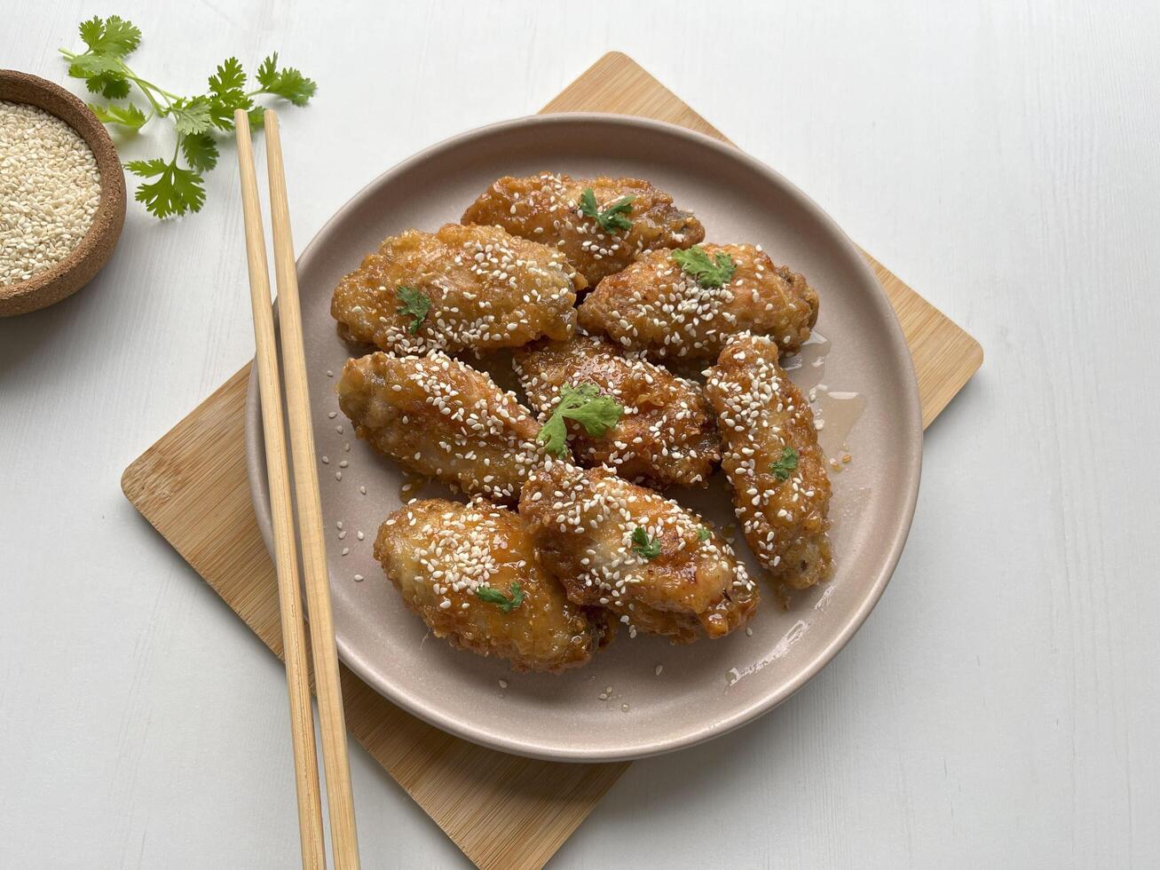 Homemade sticky Asian Honey Garlic Chicken Wings sprinkled with sesame seeds on plate. Perfect for article, recipe book and creative production. photo